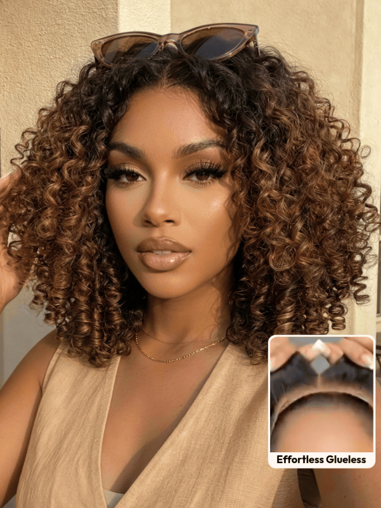A smiling woman with long, voluminous, curly hair and subtle highlights wears a sleeveless knit top. An inset shows a close-up of her scalp with the realistic hairline of the brown highlight wig labeled “Invisiknots & Glueless.”.